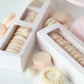 Pink macarons in box with white mini vintage cake